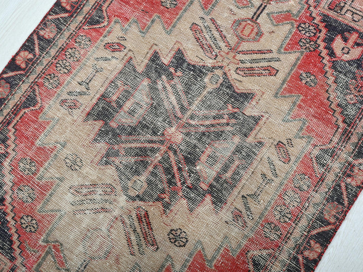 a red and black oriental rug on a white floor