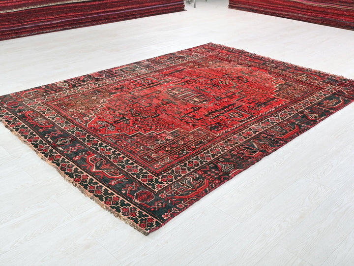a red and black oriental rug on a white floor
