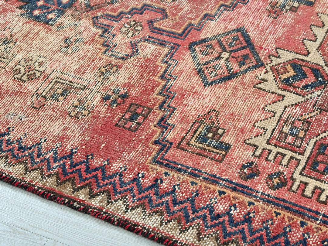 a red rug with a blue and white design on it