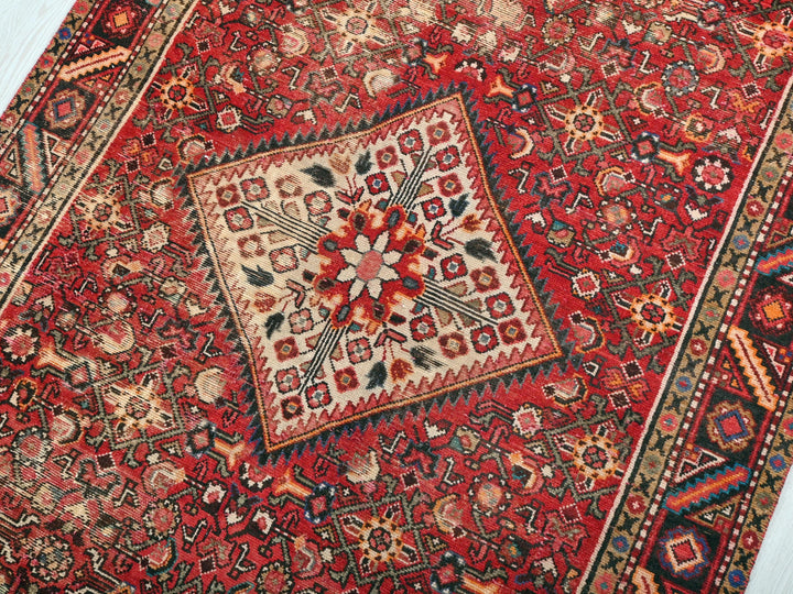 a red rug with a floral design on it