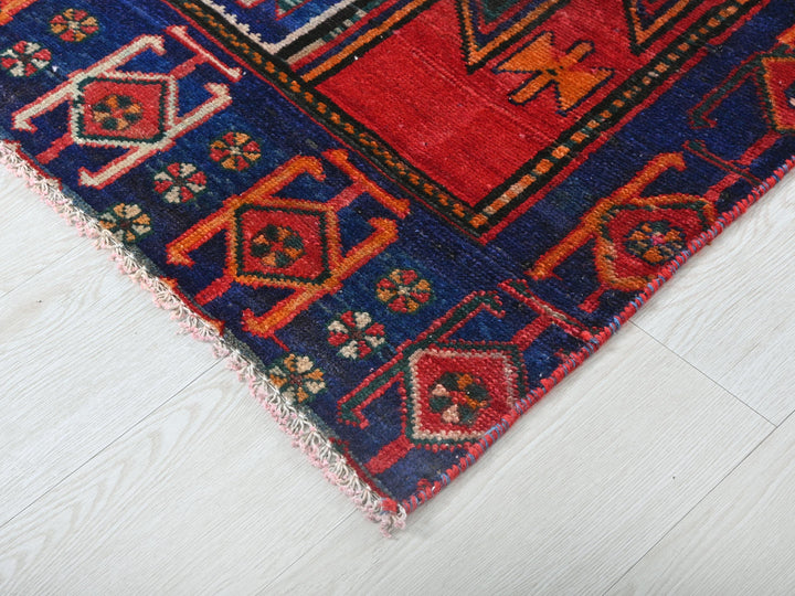 a red, blue, and yellow oriental rug on a white floor