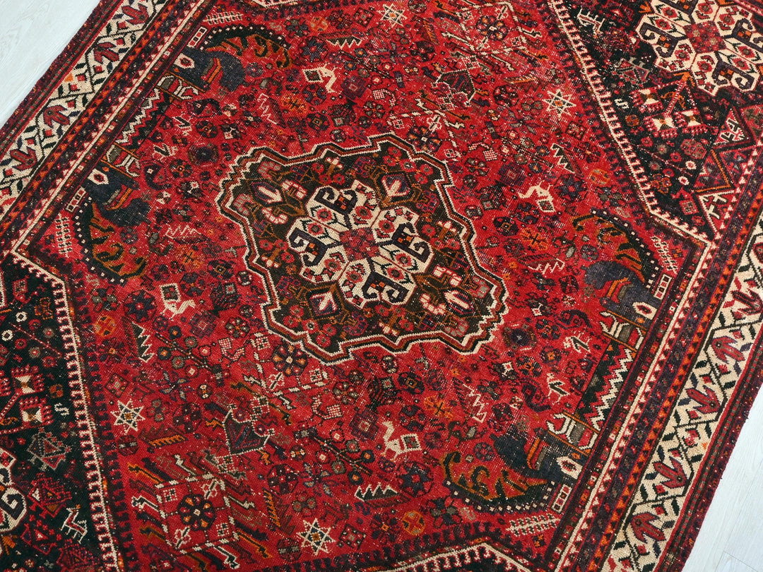 a red oriental rug on a white floor
