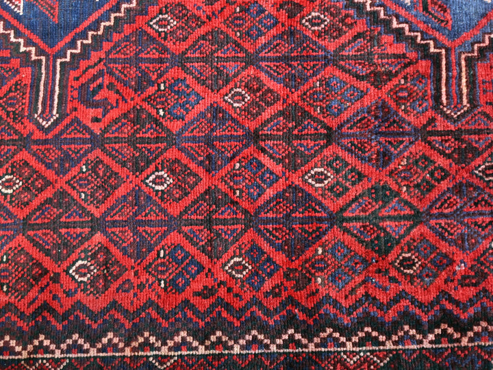 a red and blue rug with a diamond pattern
