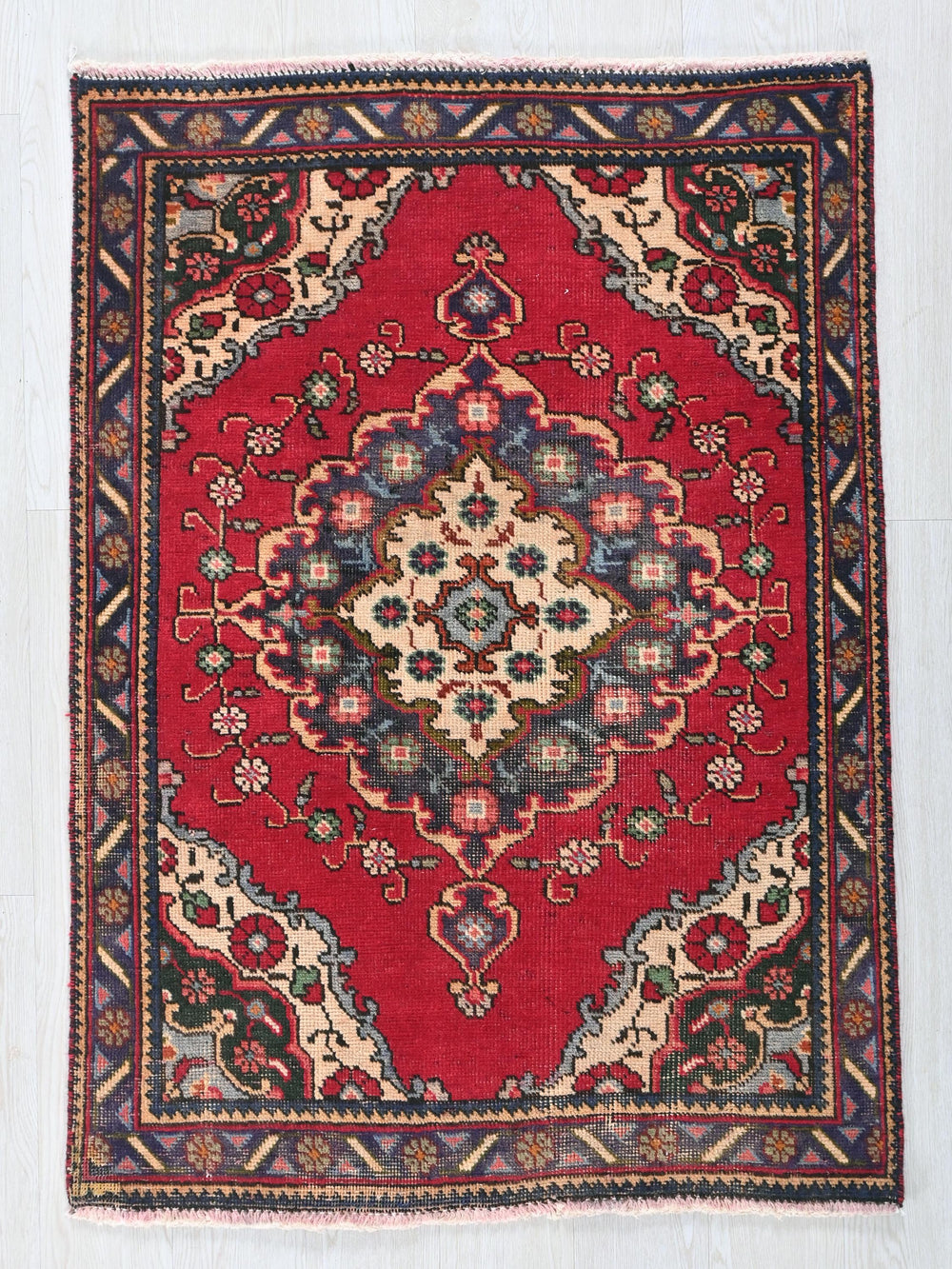 a red rug with a floral design on it