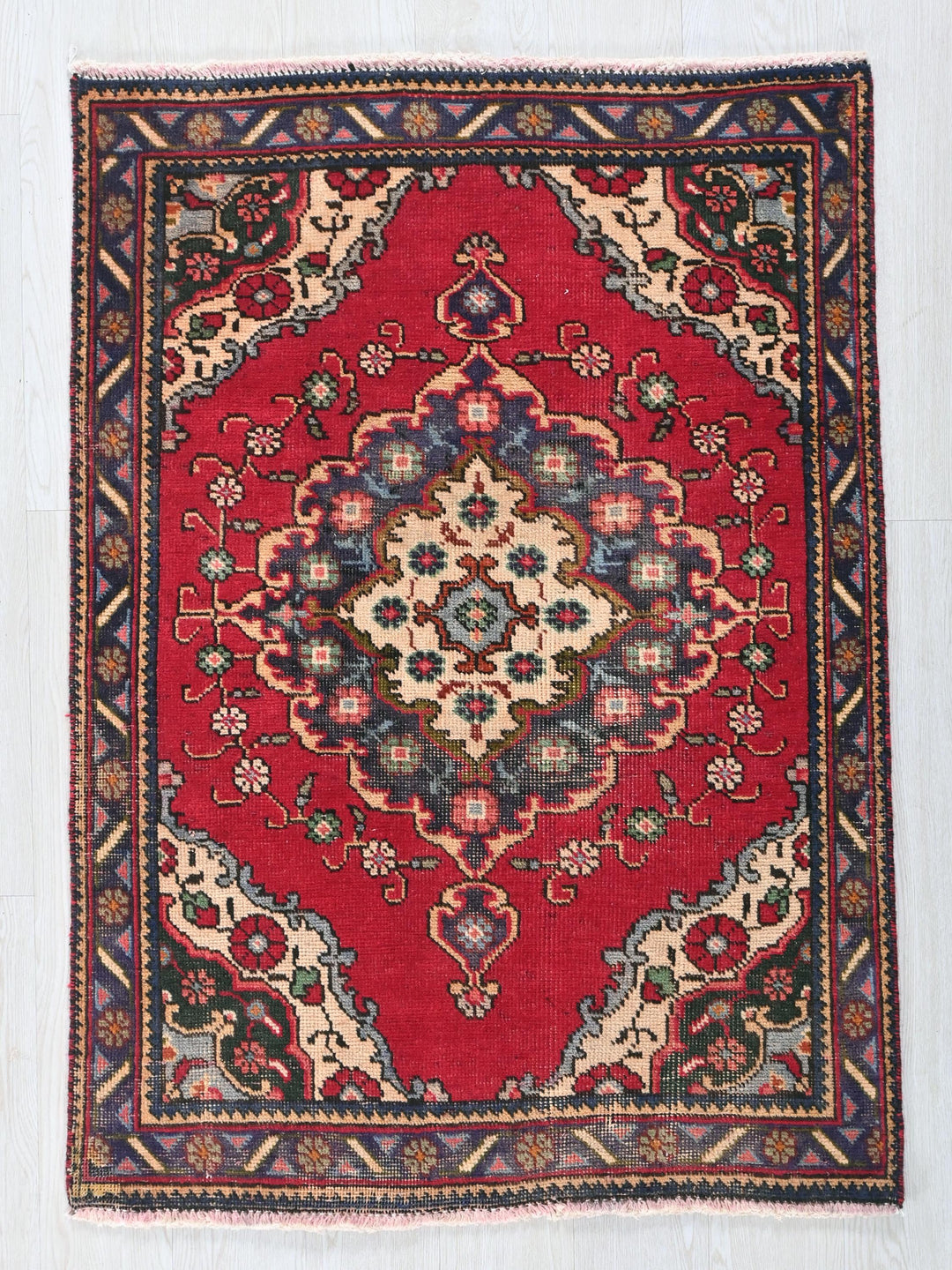 a red rug with a floral design on it
