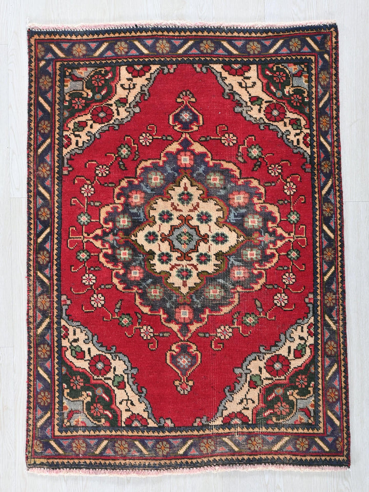 a red rug with a floral design on it