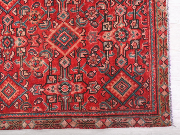 a red oriental rug with a diamond pattern