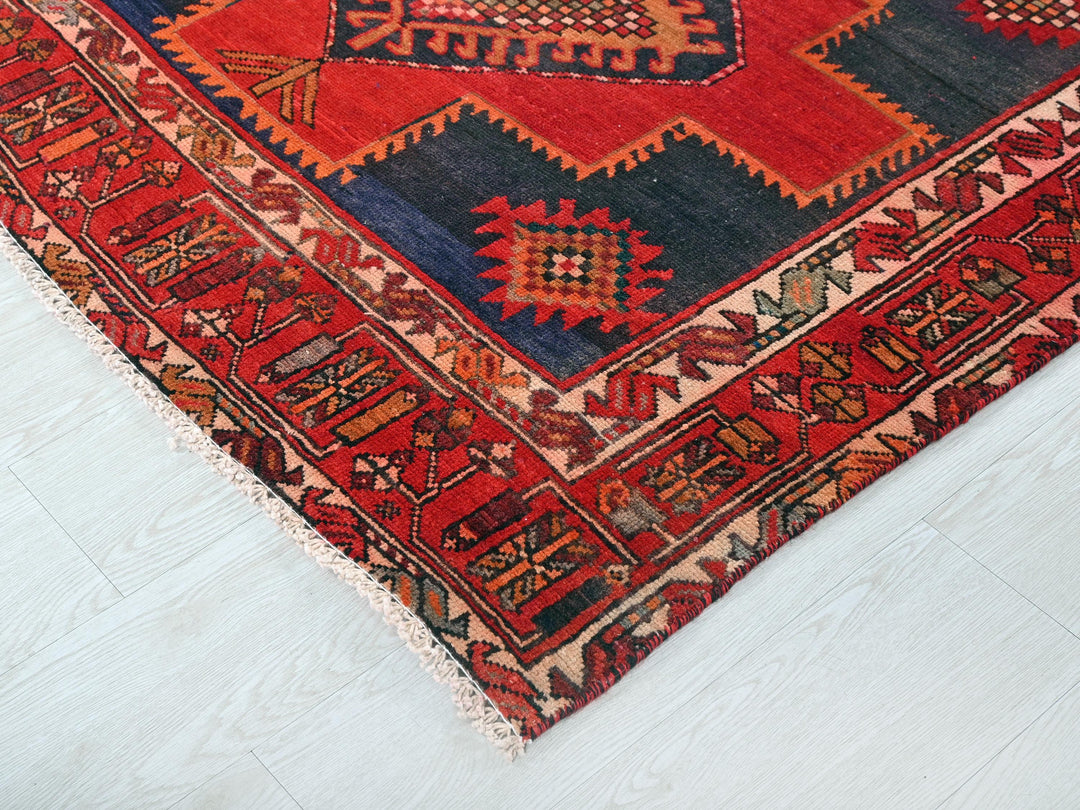 a red and blue rug on a white floor