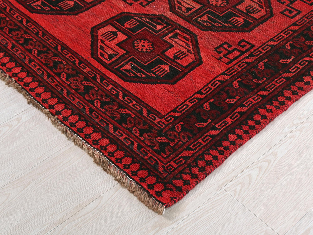 a red and black oriental rug on the floor