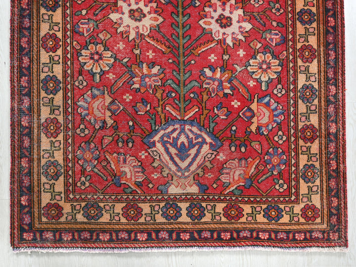 a red rug with a floral design on it