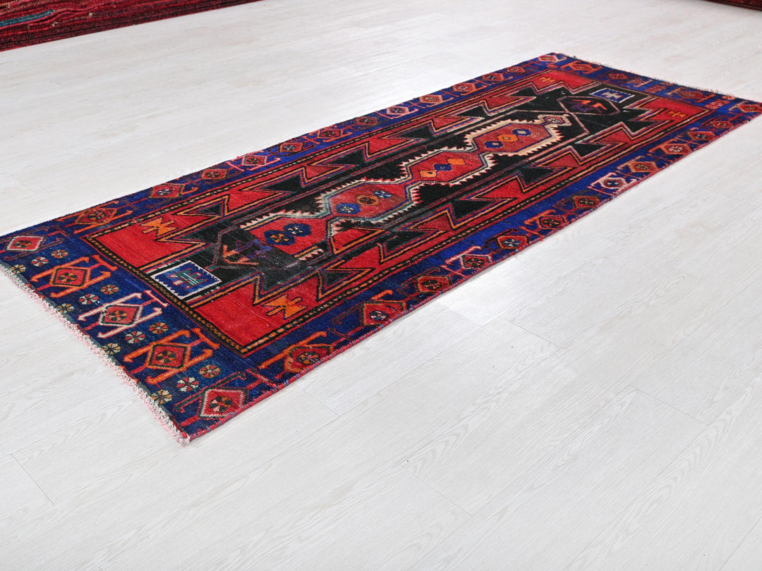 a red and blue rug on a white floor