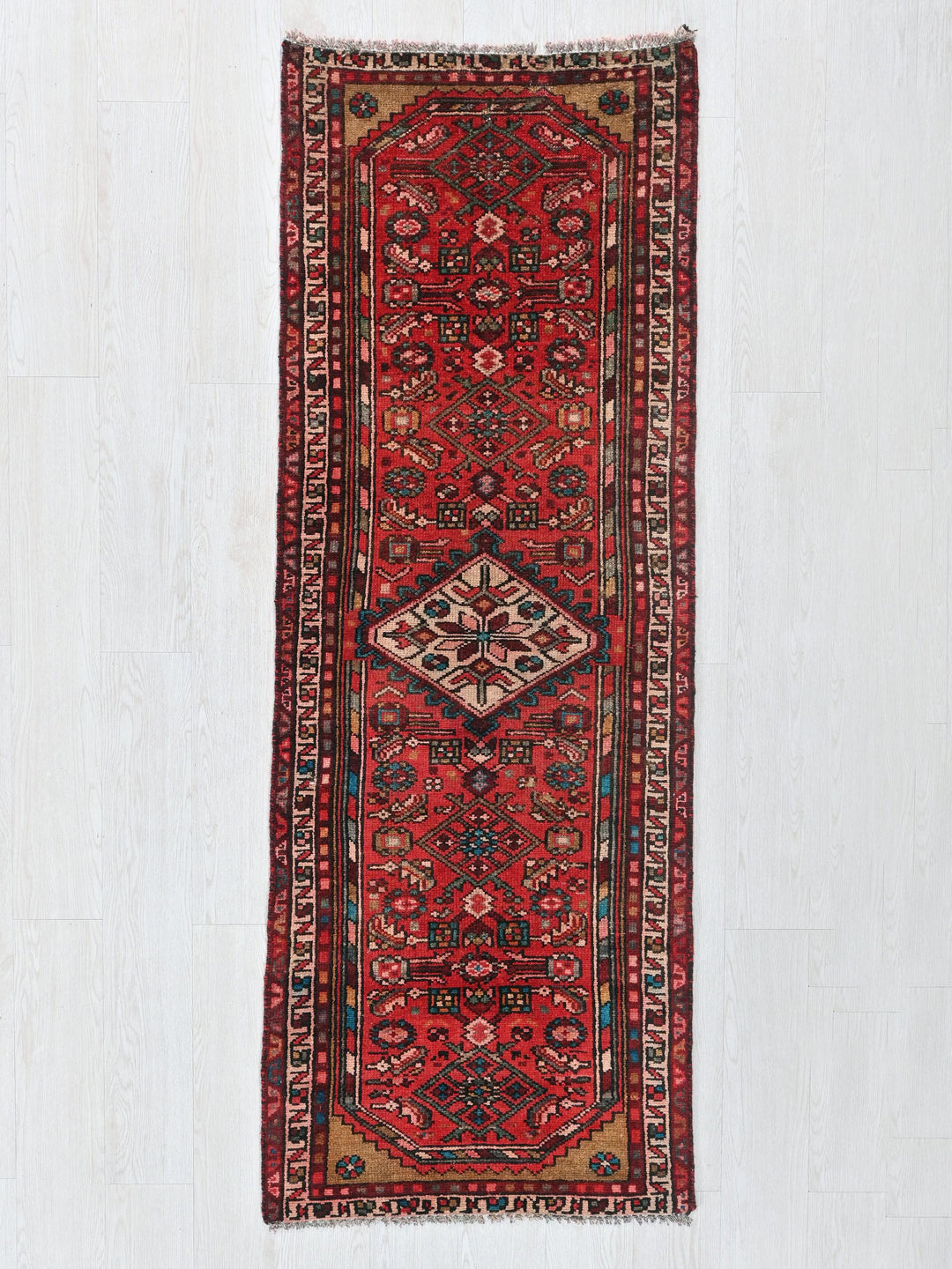 a red oriental rug hanging on a wall