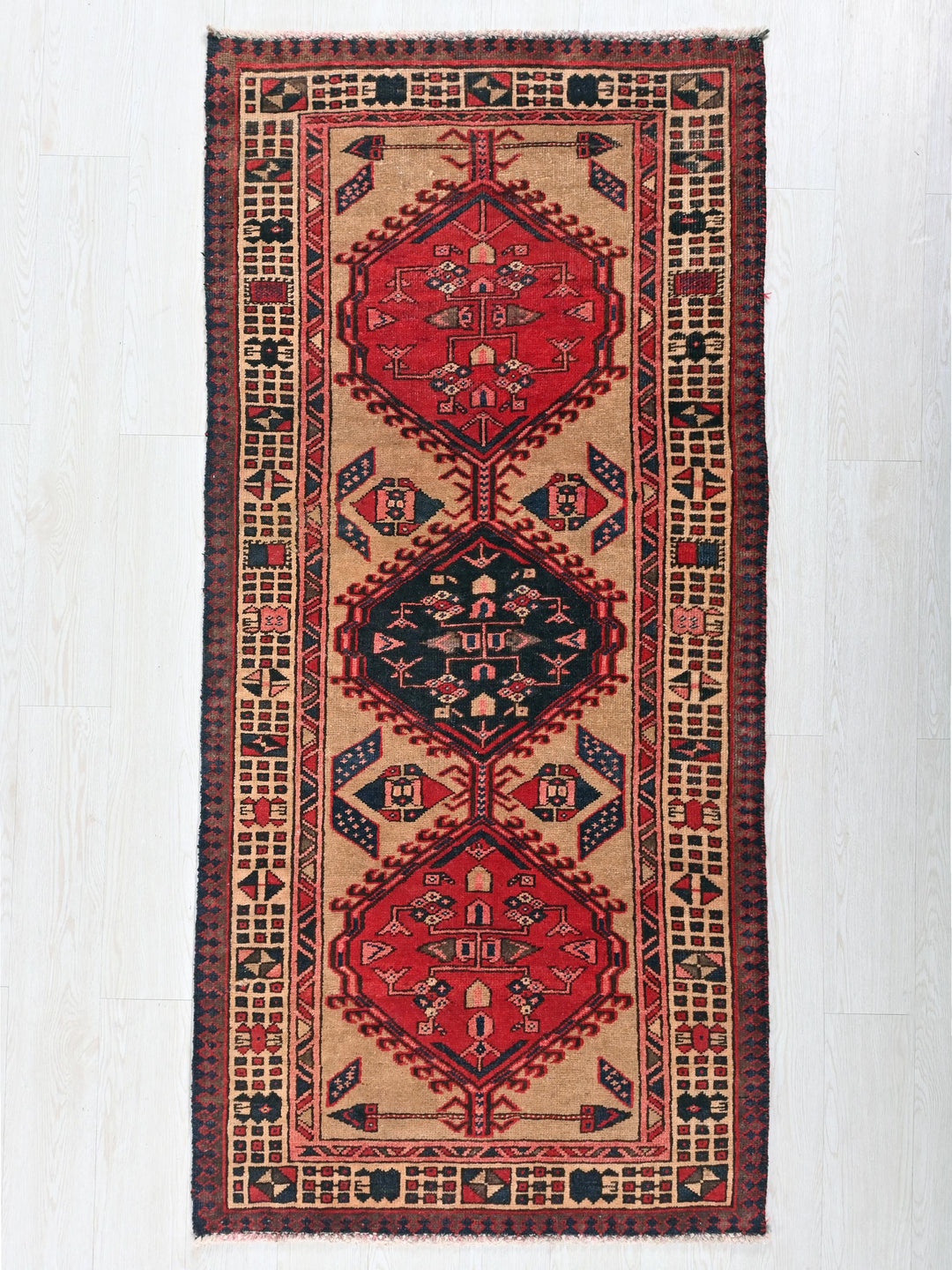 a red and black oriental rug hanging on a wall