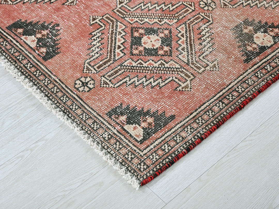 a red rug with a black and white design on it