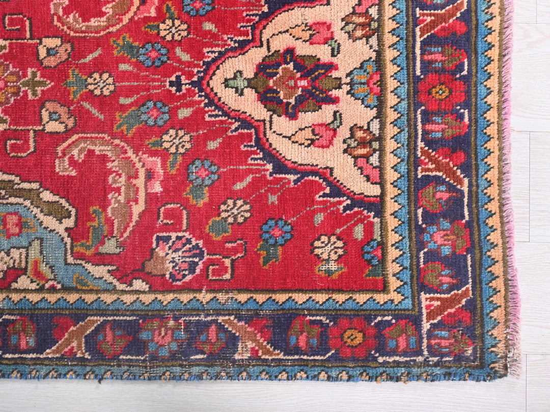 a red rug with a floral design on it