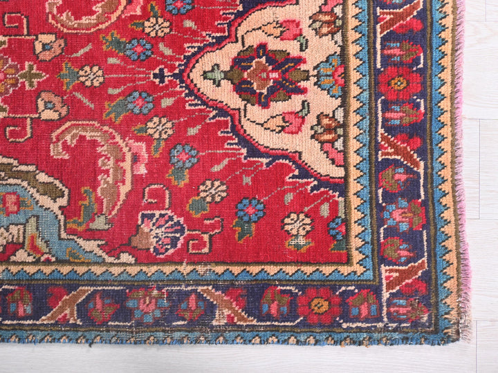 a red rug with a floral design on it