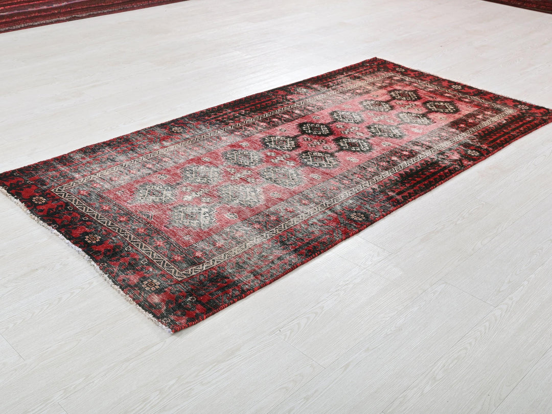 a red and black rug on a white floor