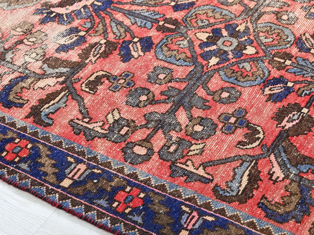 a red rug with a blue and brown design on it