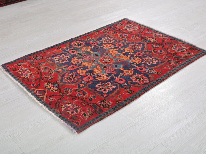 a red and blue rug on a white floor