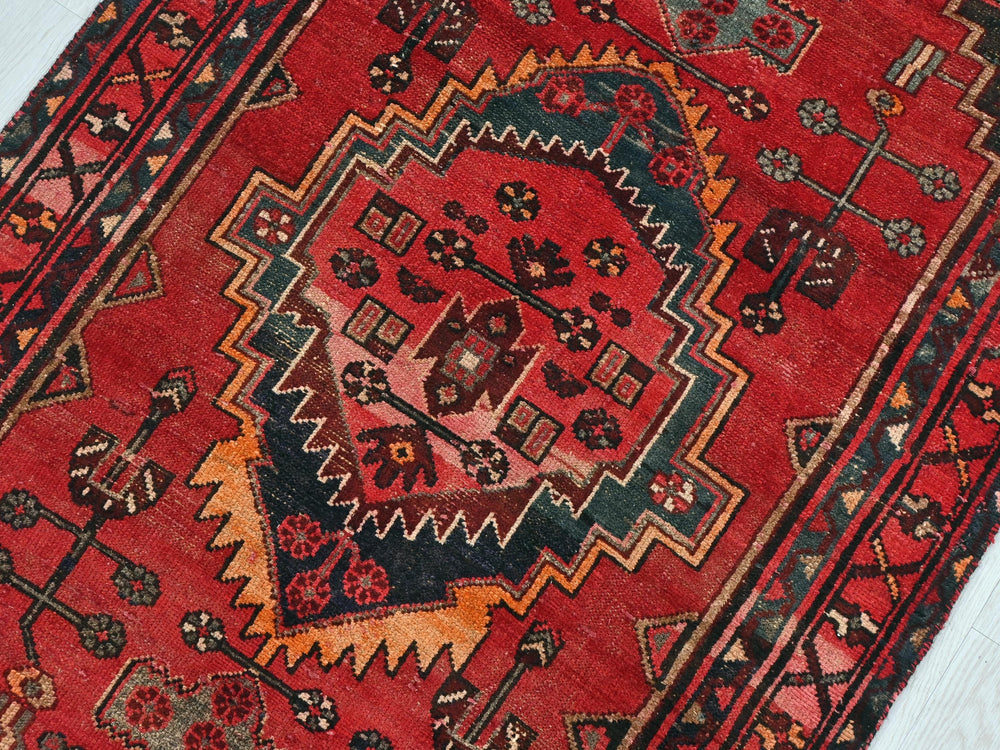 a red oriental rug on a white floor