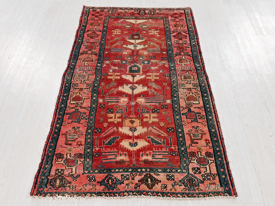 a red rug with a blue border on a white floor