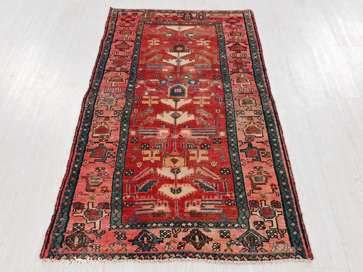 a red rug with a blue border on a white floor