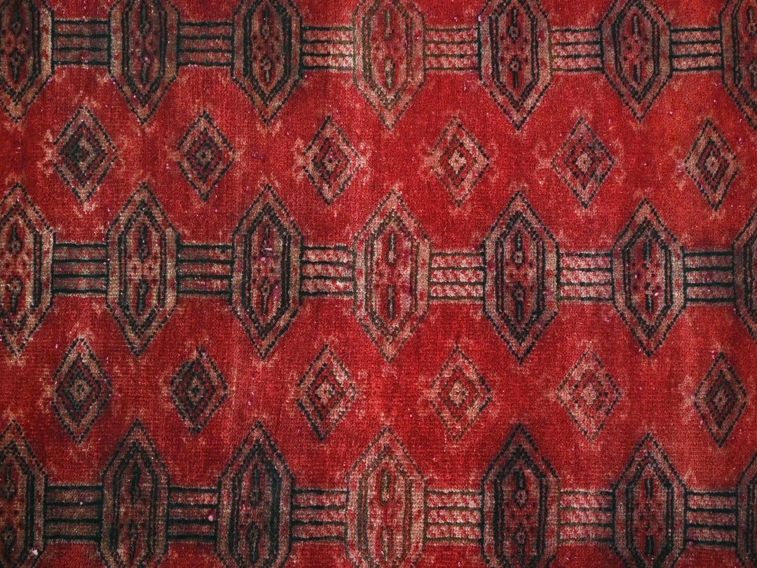 a red and black rug with a pattern on it