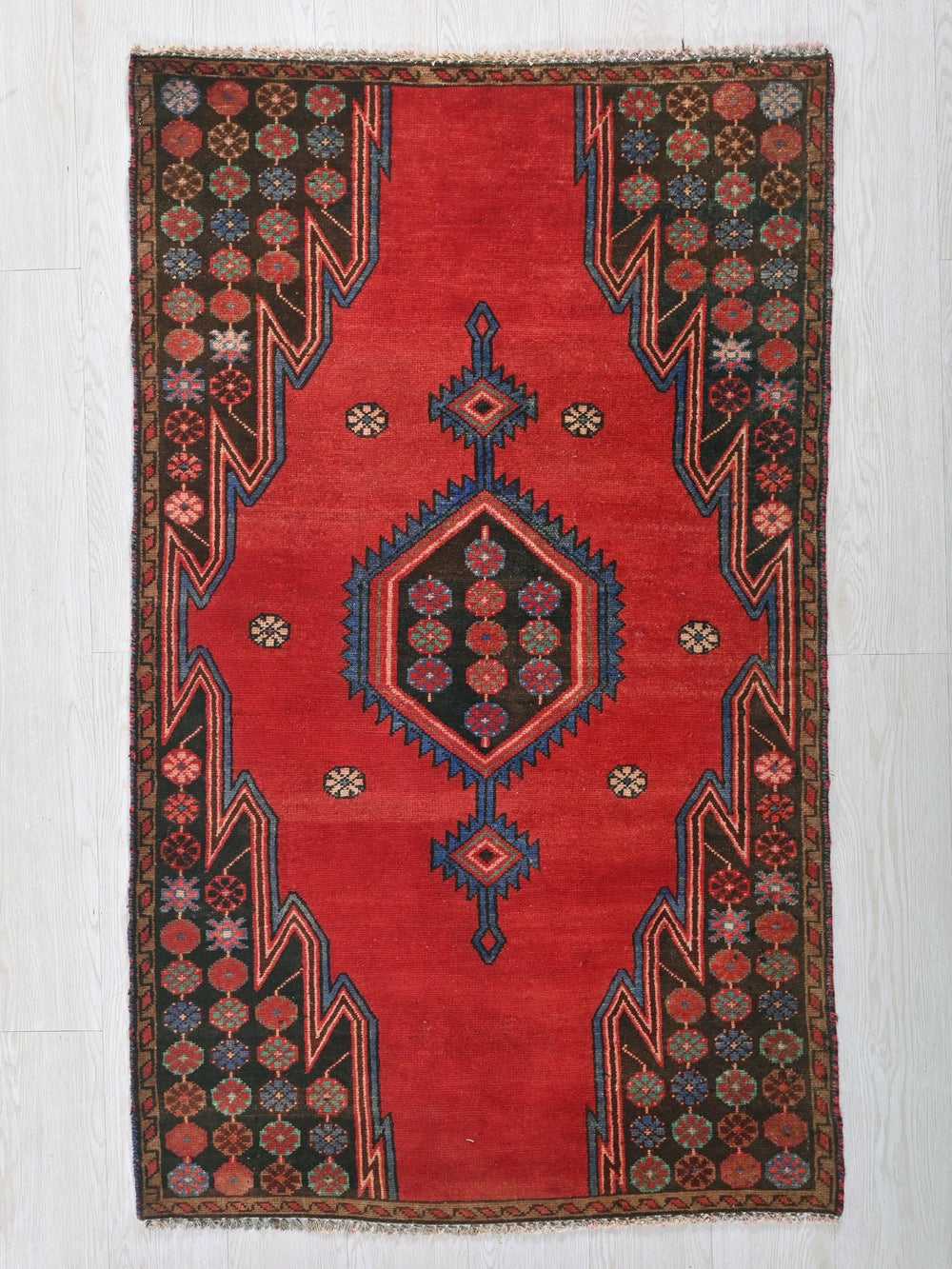 a red rug with an intricate design on it