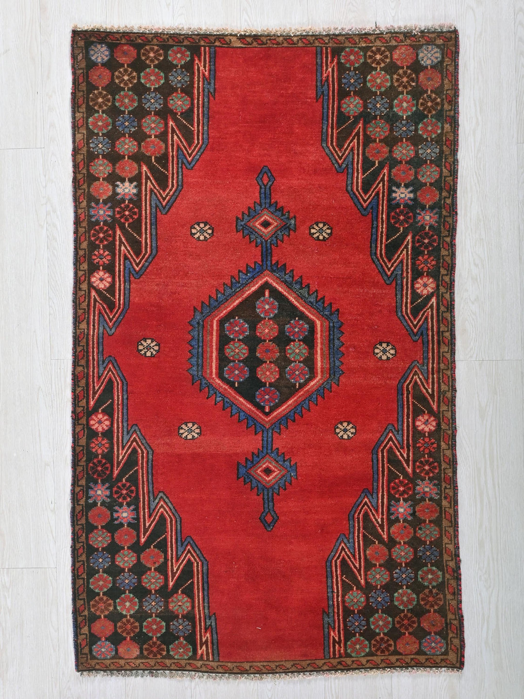 a red rug with an intricate design on it