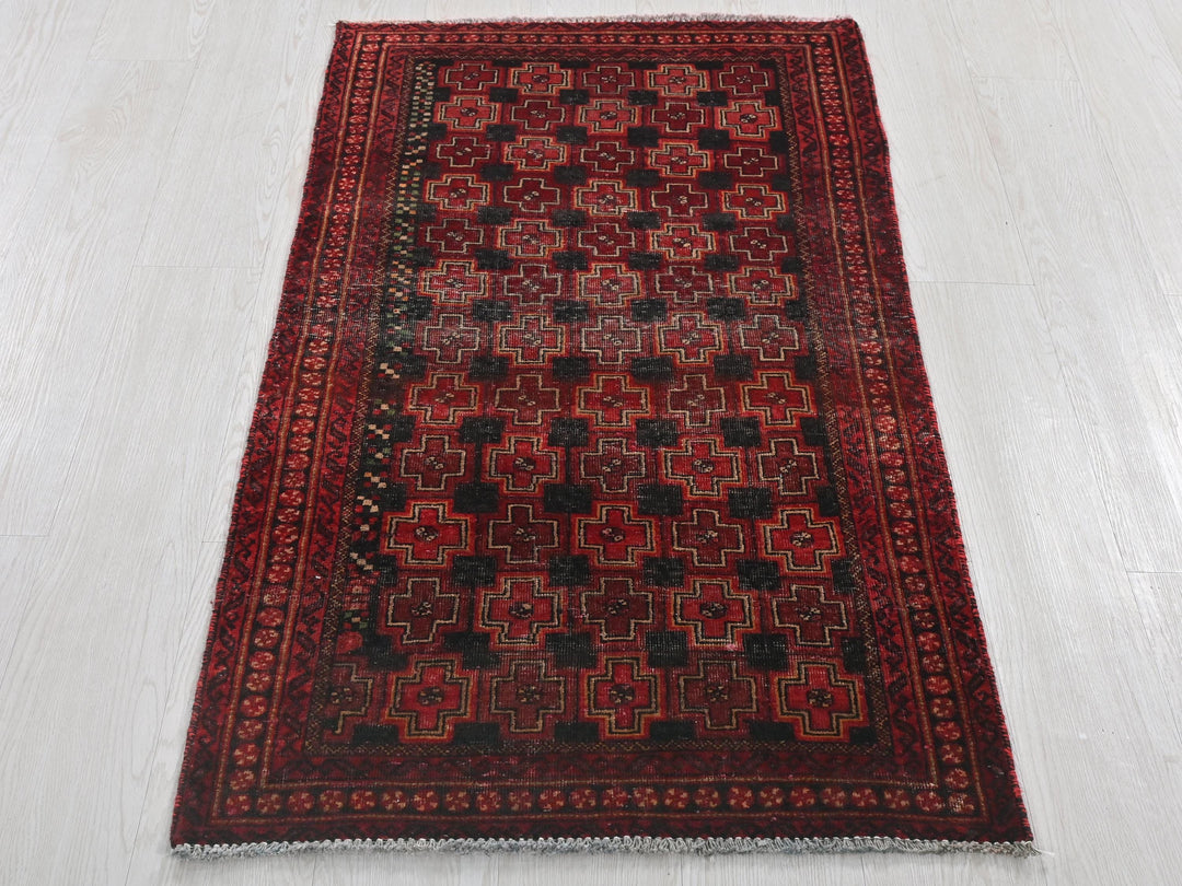 a red and black rug on a white floor