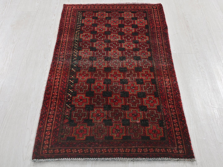 a red and black rug on a white floor