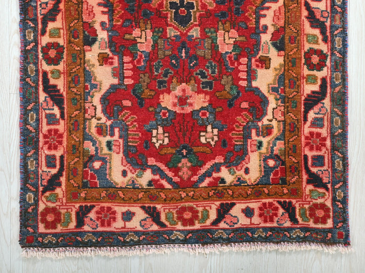 a red and blue rug on a wooden floor