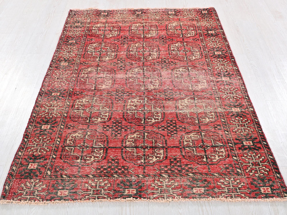 a red and black rug on a white floor