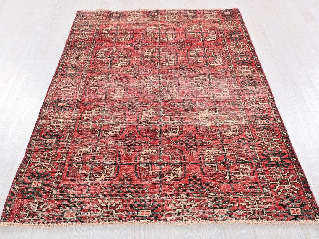 a red and black rug on a white floor
