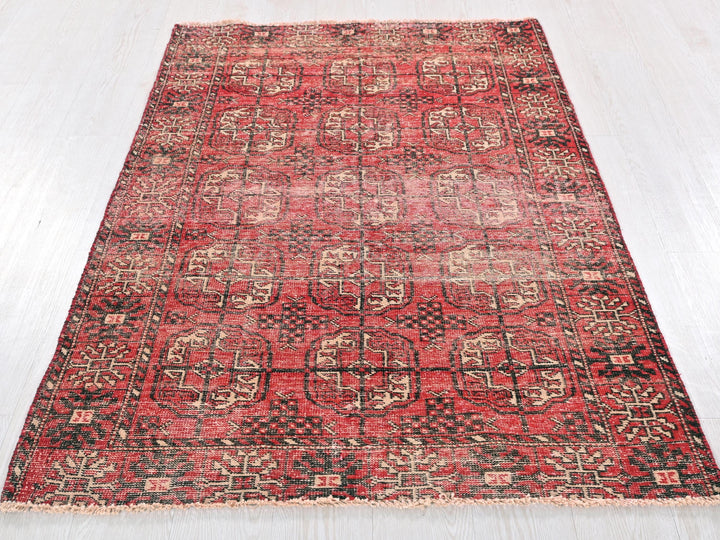 a red and black rug on a white floor