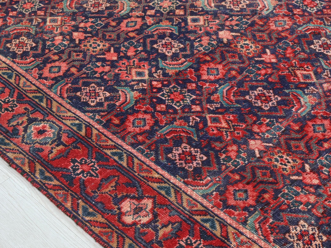 a red, blue, and green oriental rug on a white floor