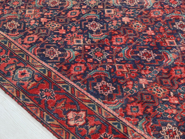 a red, blue, and green oriental rug on a white floor