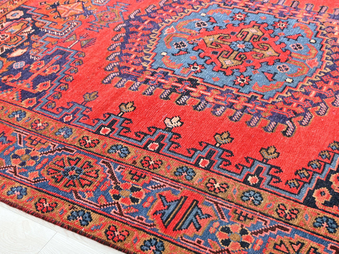 a red rug with a blue and orange design