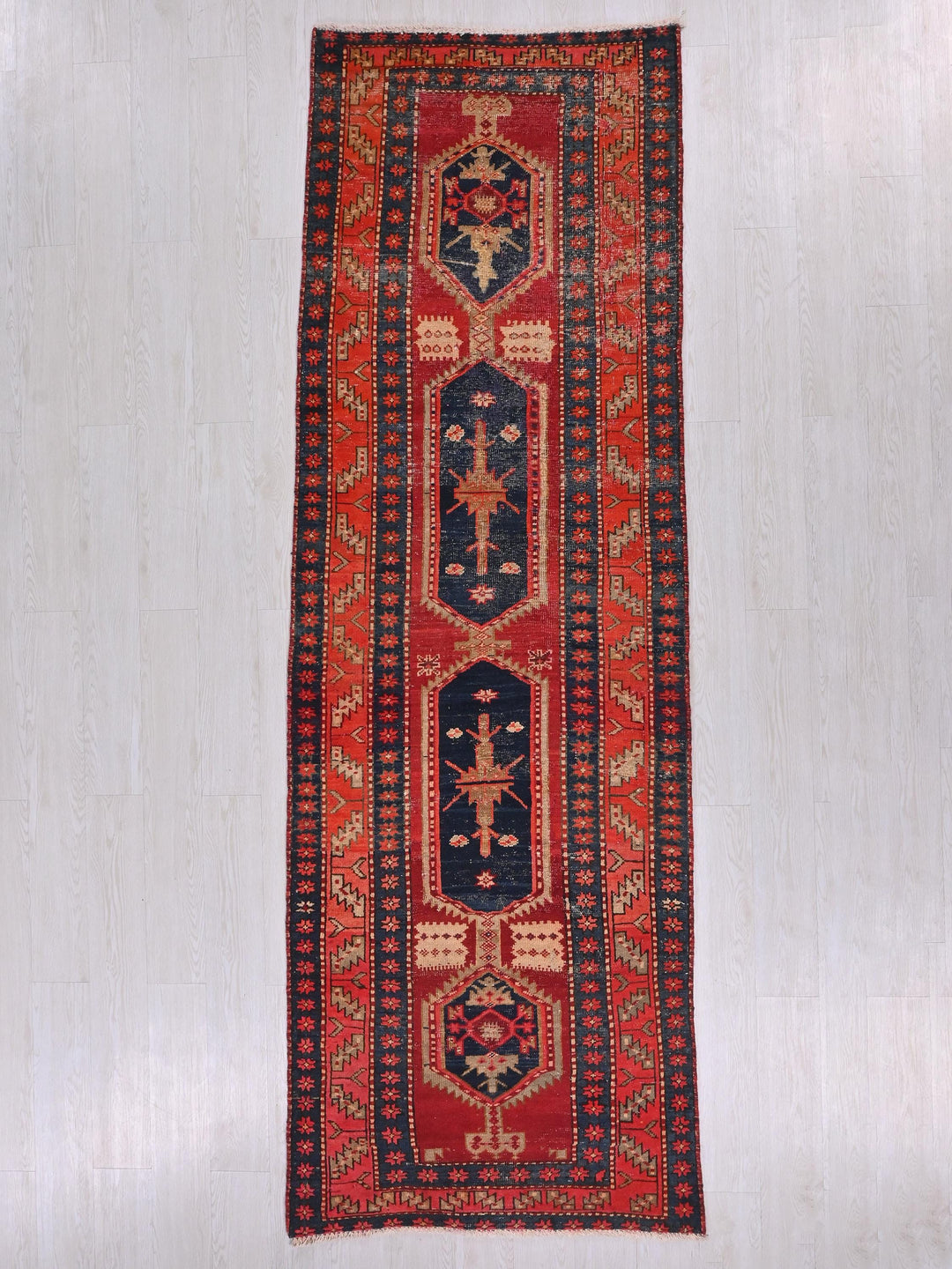 a red and blue rug hanging on a wall