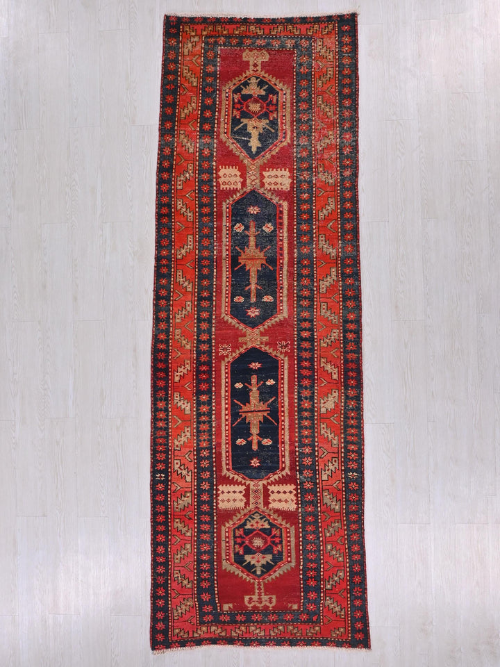 a red and blue rug hanging on a wall