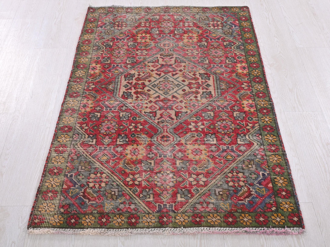a red and green rug on a white floor