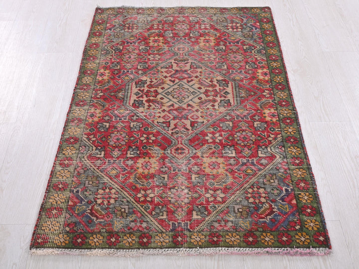 a red and green rug on a white floor