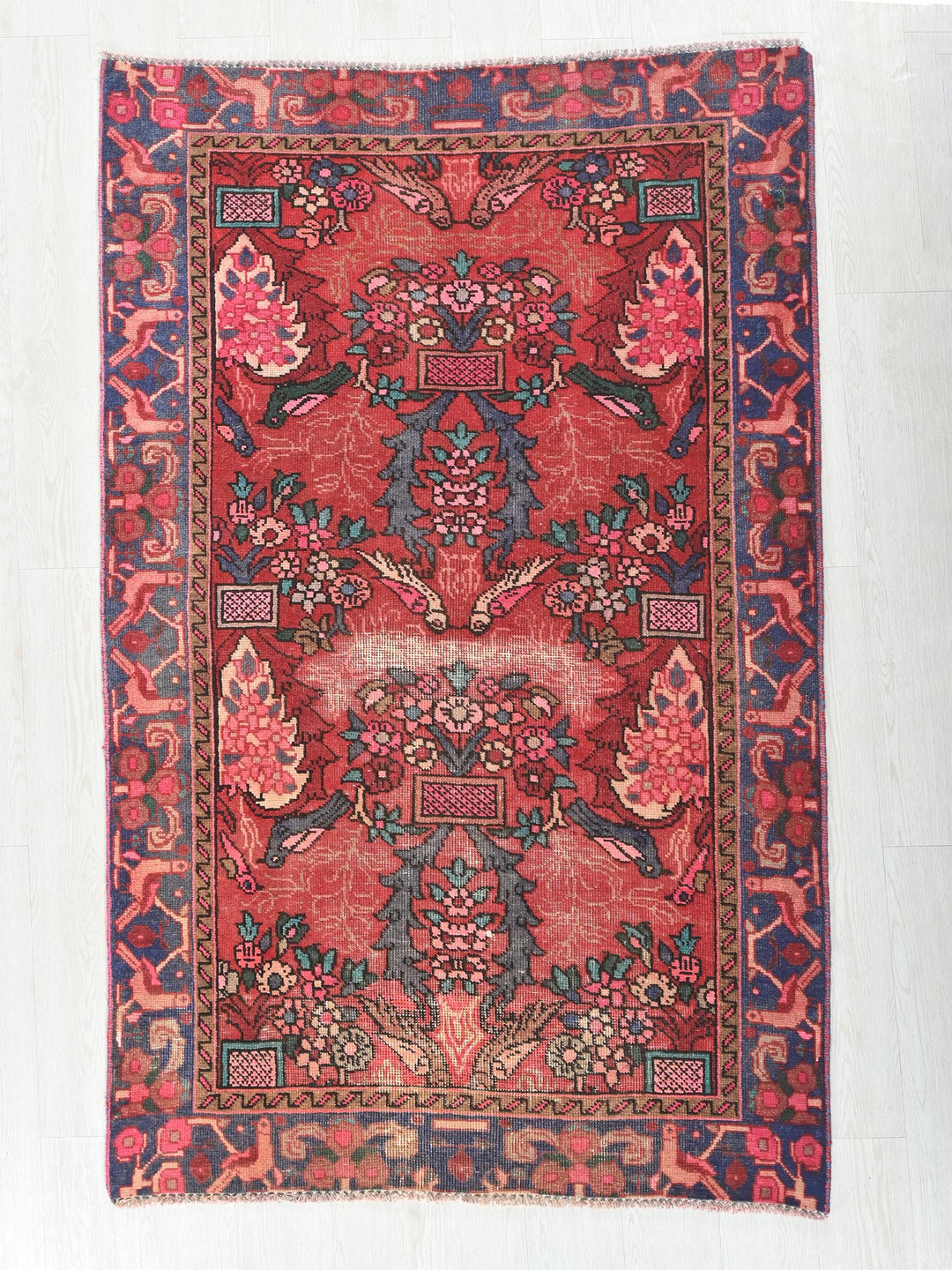 a red and blue rug with a floral design