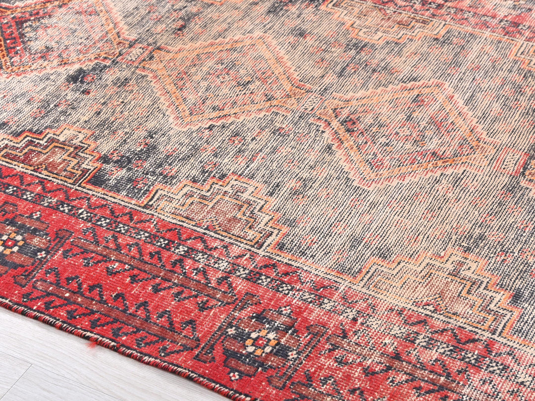 a red and blue rug on a wooden floor