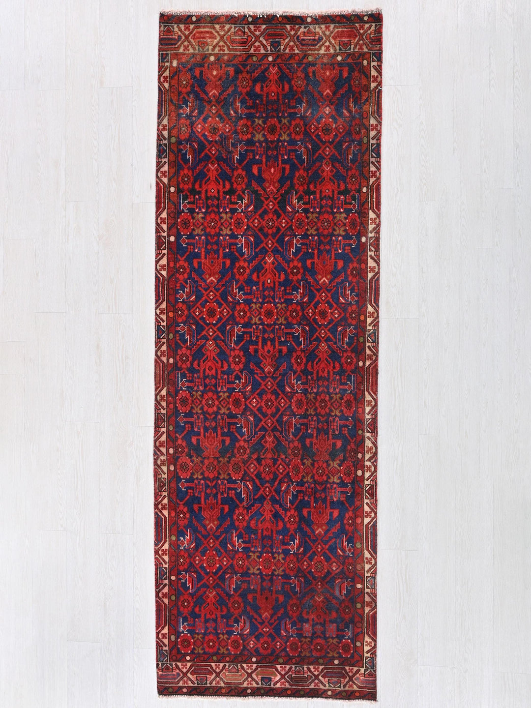 a red and blue rug hanging on a wall