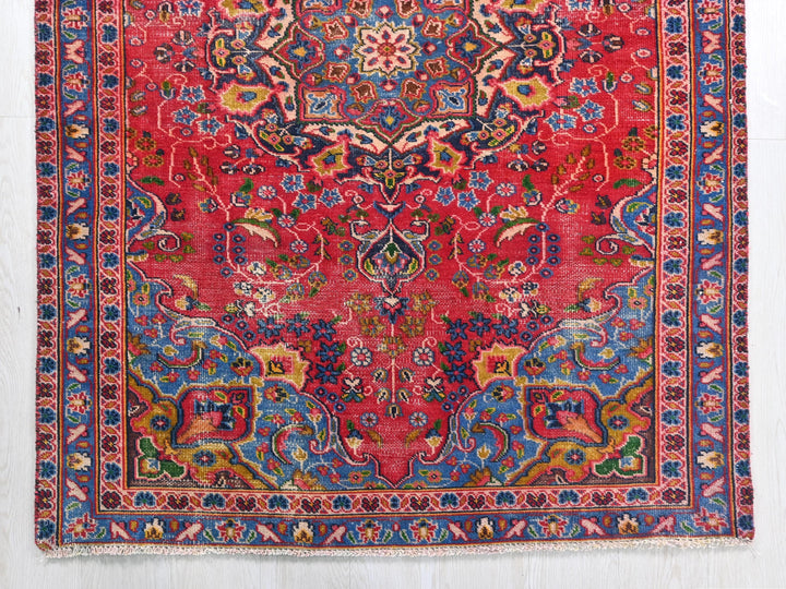 a red and blue rug with a floral design