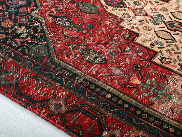 a red and black oriental rug on a white floor