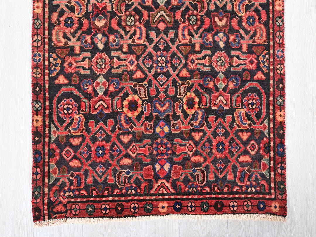 a red and black rug on a white floor
