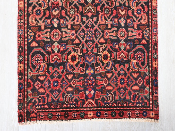 a red and black rug on a white floor