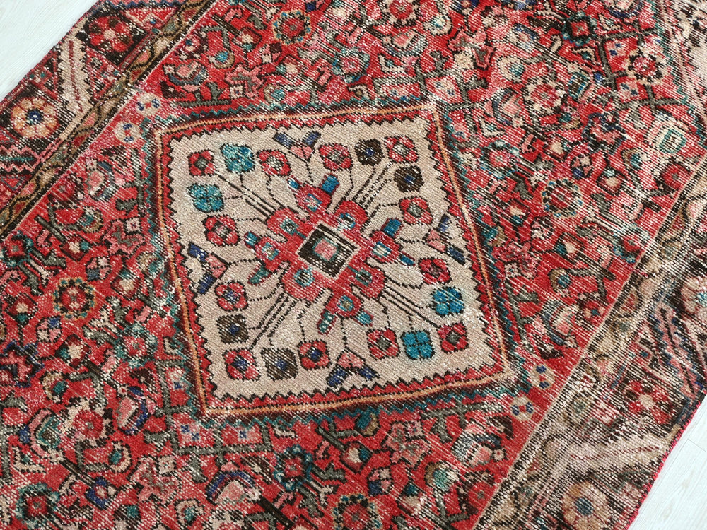 a red rug with a floral design on it